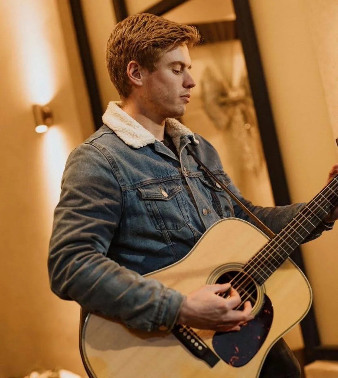 Jake Woodhams playing acoustic guitar